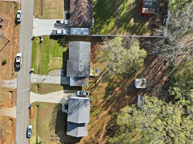 an aerial view of residential houses with outdoor space and trees