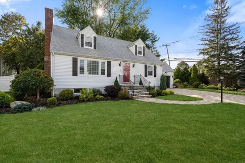 a front view of a house with a yard and trees