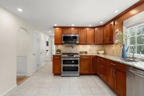 a kitchen with stainless steel appliances granite countertop a stove a sink and a refrigerator