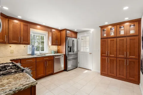 a kitchen with stainless steel appliances granite countertop a refrigerator stove top oven and sink