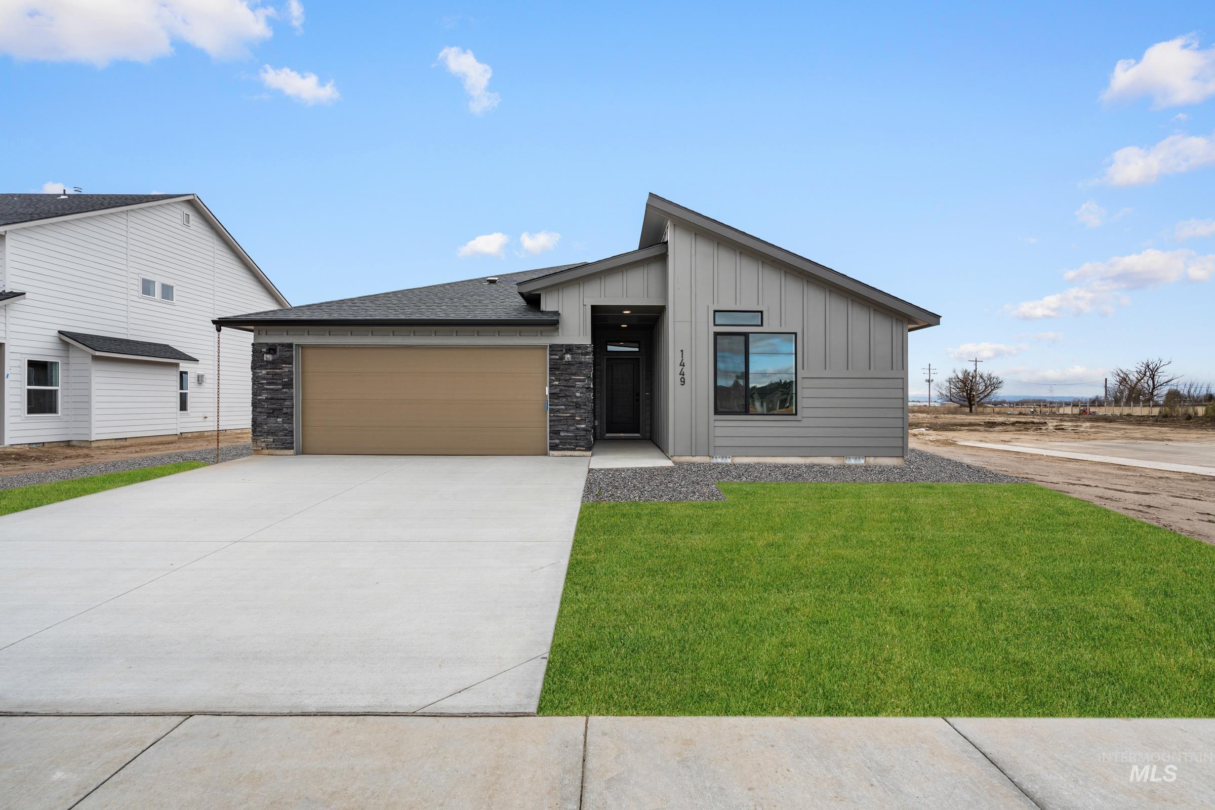 1449 Covington Street Middleton, ID 83644 - Photo 1 of 21 View of front facade with a garage, board and batten siding, concrete driveway, a front lawn, and stone siding