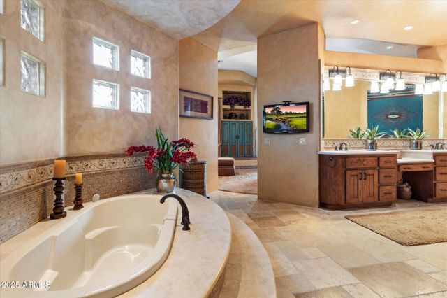 a bathroom with a tub sink and mirror
