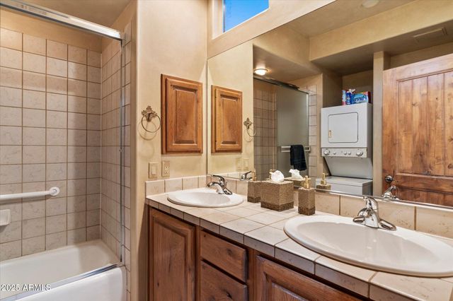 a bathroom with a double vanity sink a mirror and a bathtub