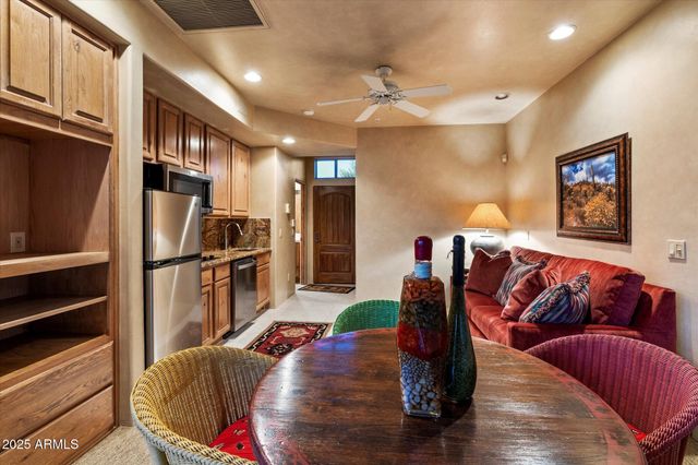 a living room with furniture kitchen view and a wooden floor