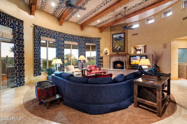 a living room with furniture a fireplace and a chandelier