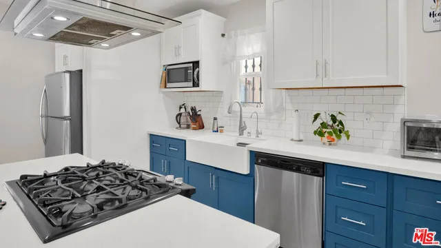 a kitchen with stainless steel appliances a sink stove and refrigerator