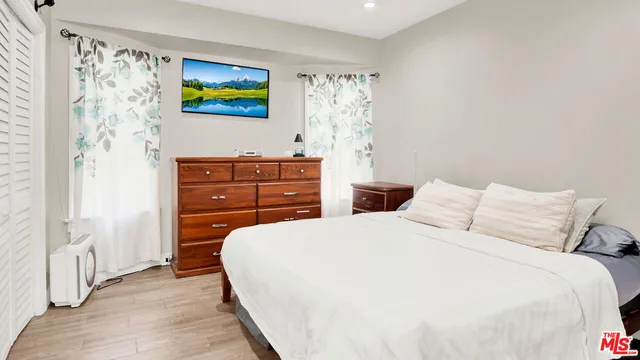 a bedroom with a bed and a painting on the wall