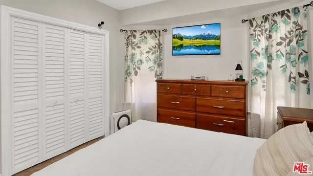 a bedroom with a bed and painting on the wall