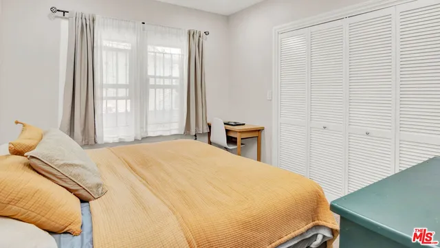 a bed sitting in a bedroom next to a window