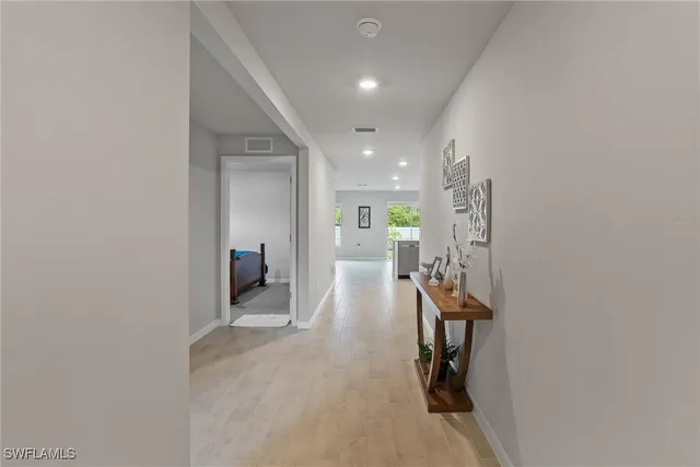 a bedroom with a bed and a lamp on the dresser