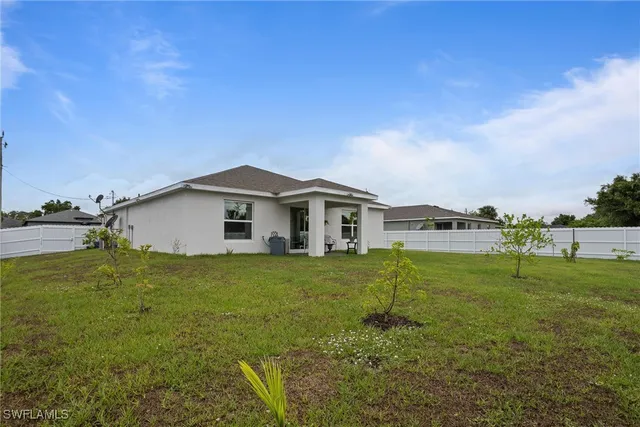 a view of a house with a big yard and a large tree