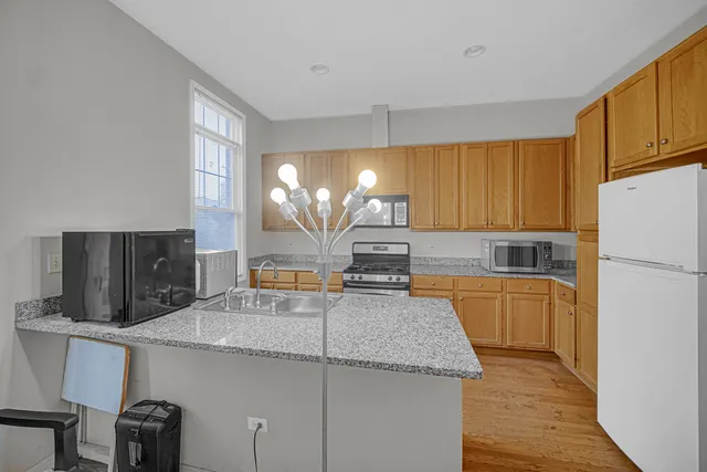 a kitchen with stainless steel appliances granite countertop a sink refrigerator and cabinets
