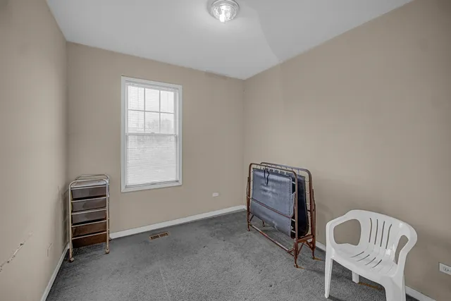 a bedroom with a bed chair and a window