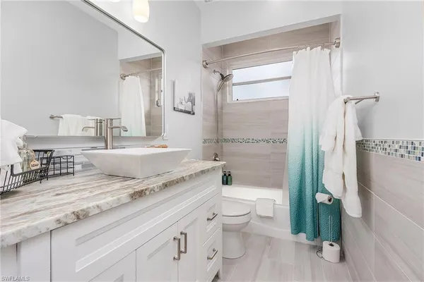 a spacious bathroom with a granite countertop sink toilet and shower