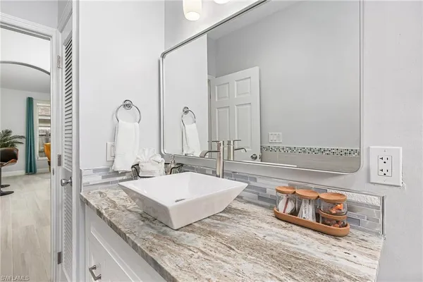 a bathroom with a granite countertop sink and a mirror