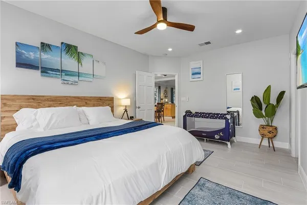 a bedroom with a bed a chandelier and a couch