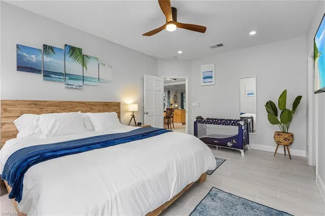 a bedroom with a bed a chandelier and a couch