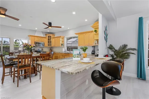 a kitchen with sink refrigerator dining table and chairs
