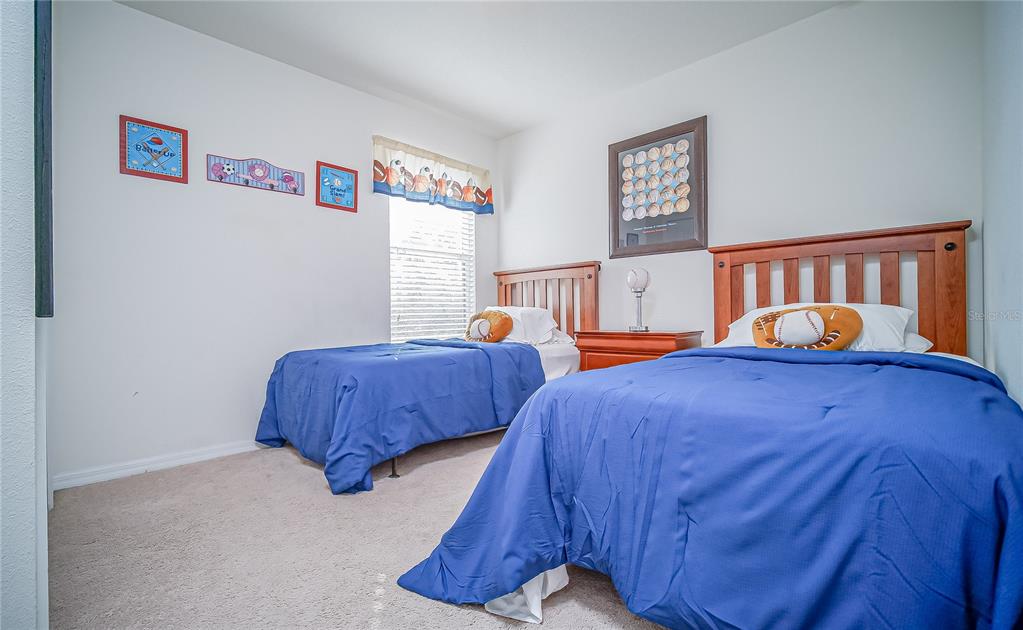 2528 Dharma Circle Kissimmee, FL 34746 - Photo 19 of 46 a bedroom with 2 bed and painting on the wall