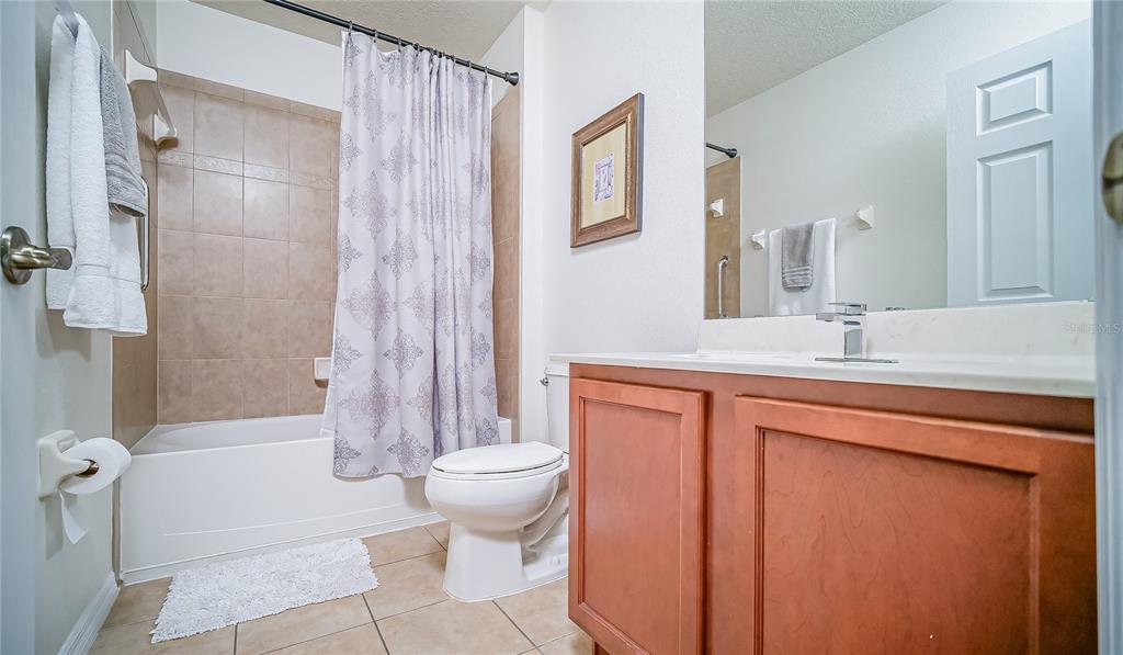 2528 Dharma Circle Kissimmee, FL 34746 - Photo 20 of 46 a bathroom with a sink a toilet a mirror and shower