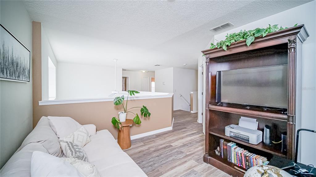 2528 Dharma Circle Kissimmee, FL 34746 - Photo 25 of 46 a living room with furniture and a flat screen tv