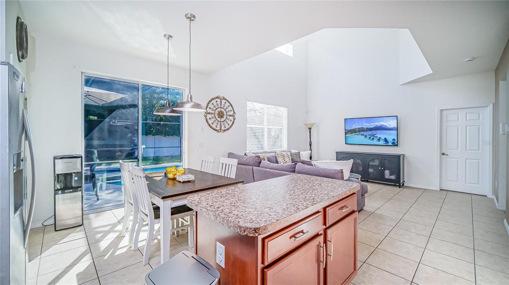 2528 Dharma Circle Kissimmee, FL 34746 - Photo 9 of 46 a living room with dining table and a clock on the wall