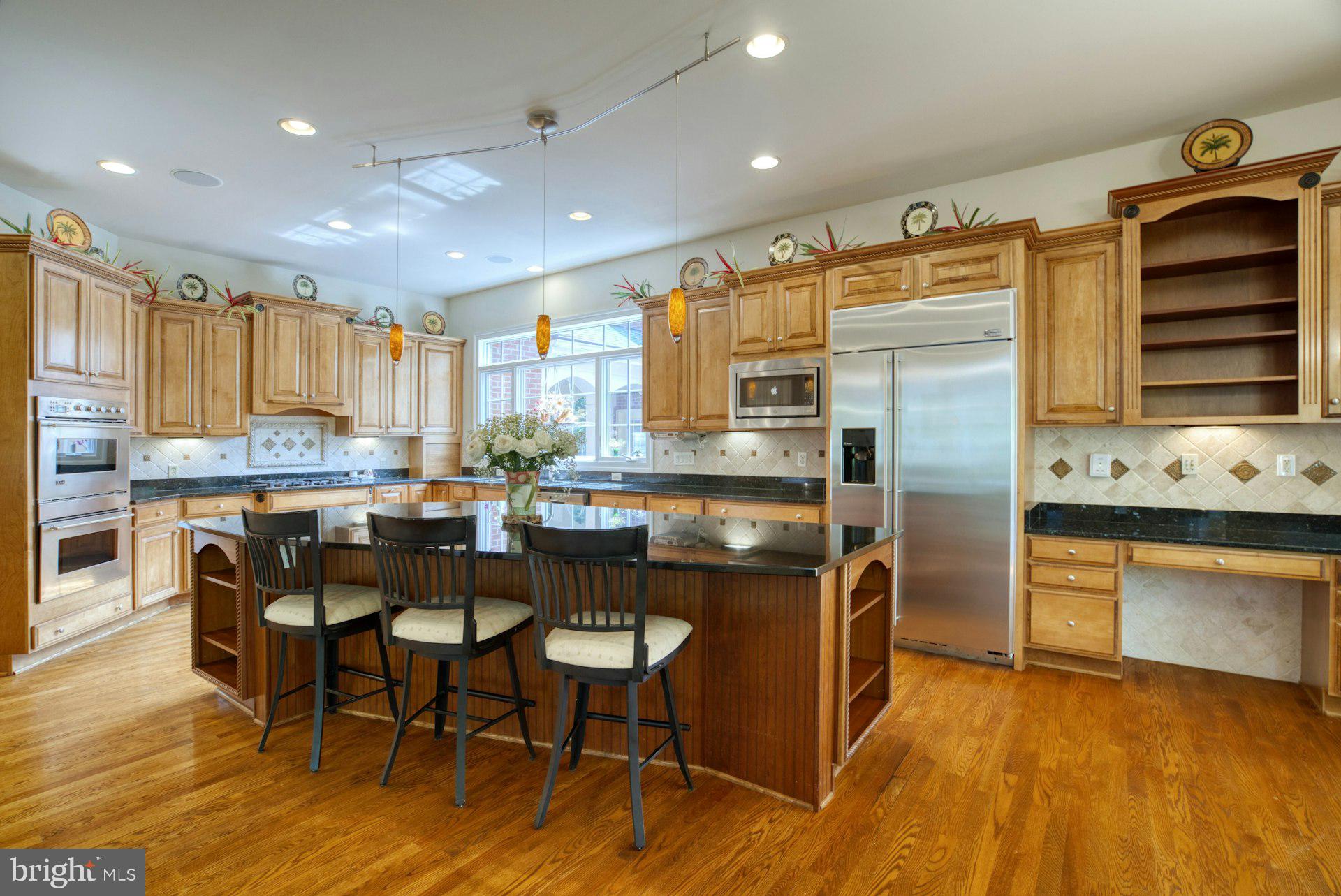 10300 Hampton Road Fairfax Station, VA 22039 - Photo 20 of 89 a kitchen with stainless steel appliances granite countertop a stove top oven a sink dishwasher and a dining table with wooden floor