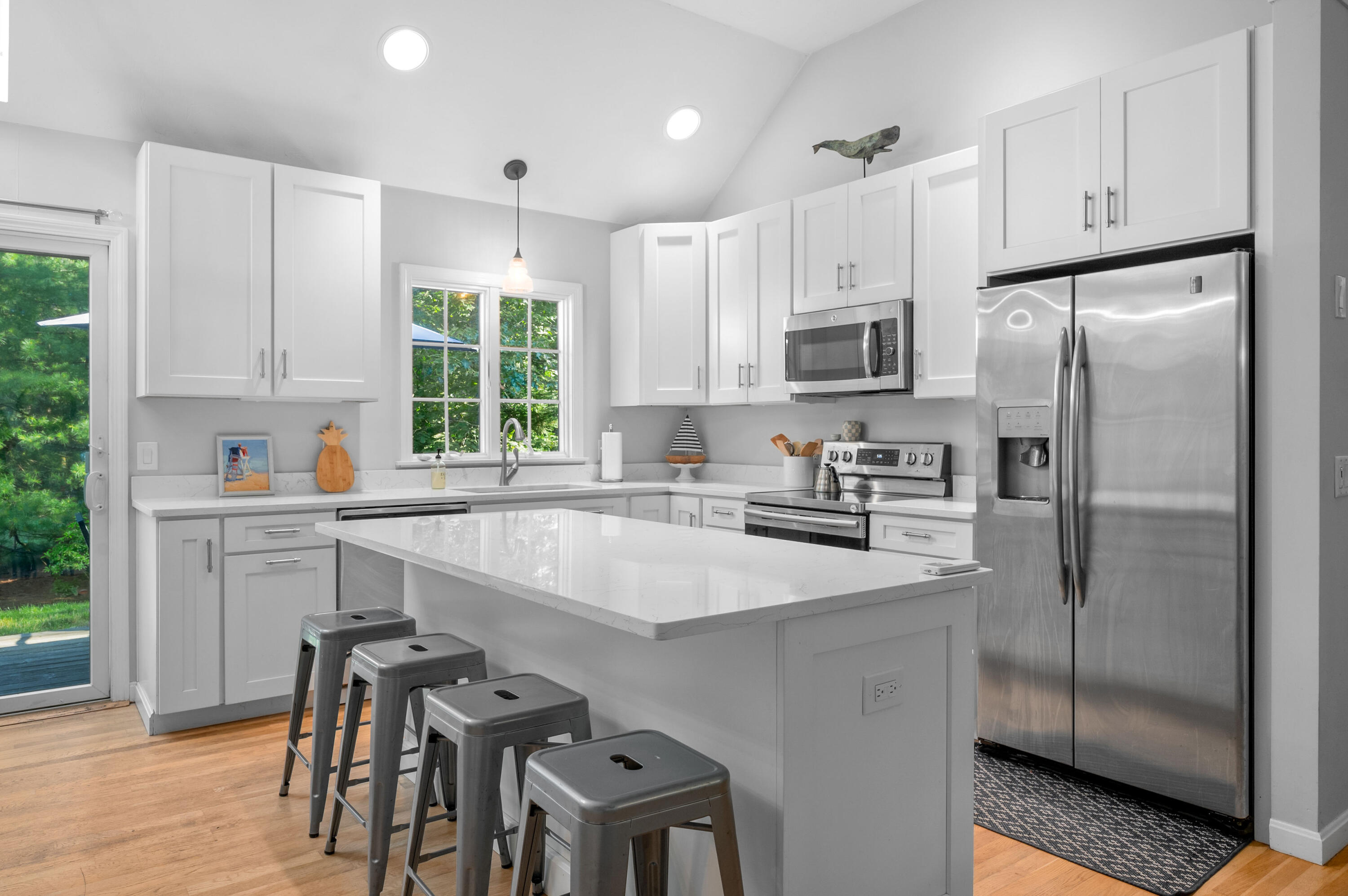 11 Quanset Road Orleans, MA 02653 - Photo 12 of 36 a kitchen with stainless steel appliances granite countertop a refrigerator a sink a stove and white cabinets with wooden floor