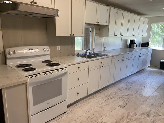 a kitchen with granite countertop cabinets and white appliances