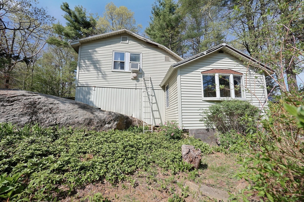 6 Hillside Road Holland, MA 01521 - Photo 1 of 27 a view of a yard in front of a house with plants and large trees