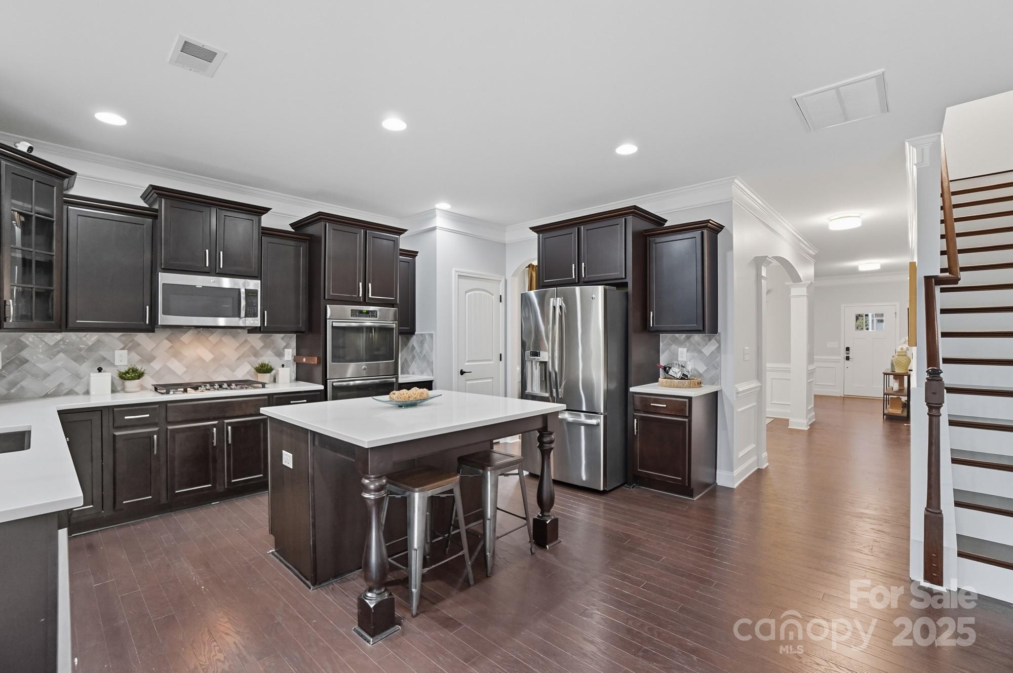 310 Annatto Way Fort Mill, SC 29708 - Photo 15 of 48 a kitchen with stainless steel appliances a stove a sink a refrigerator and chairs