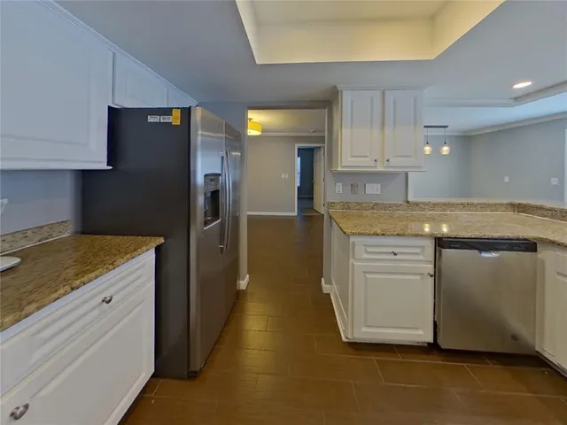 a kitchen with granite countertop cabinets and refrigerator