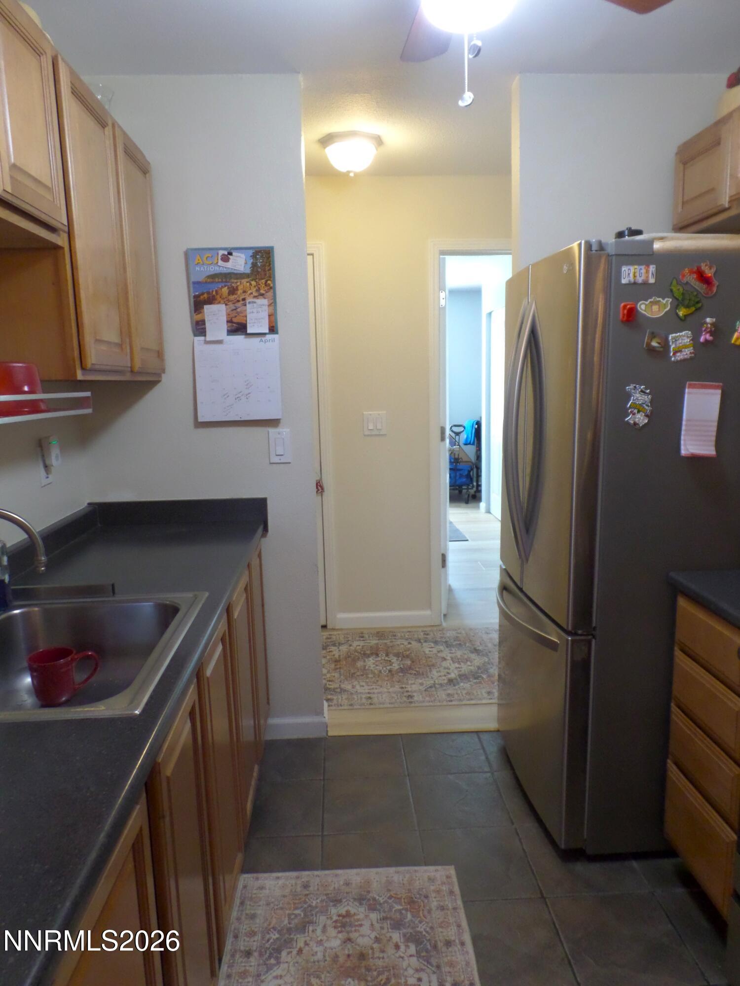 3890 East Leonesio Drive, Unit D1 Reno, NV 89512 - Photo 11 of 32 a kitchen with stainless steel appliances granite countertop a refrigerator and a sink