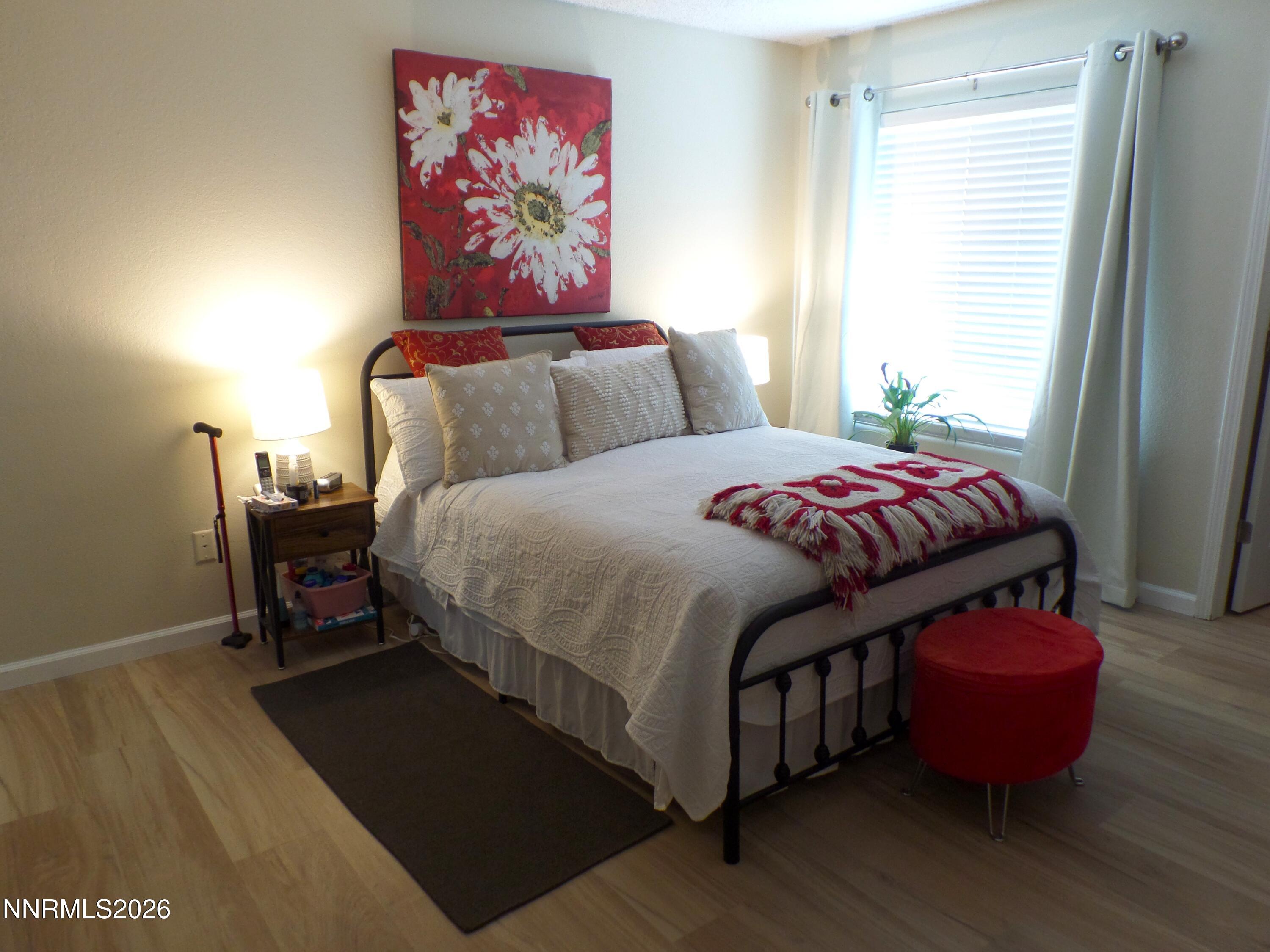 3890 East Leonesio Drive, Unit D1 Reno, NV 89512 - Photo 16 of 32 a bedroom with bed and wooden floor