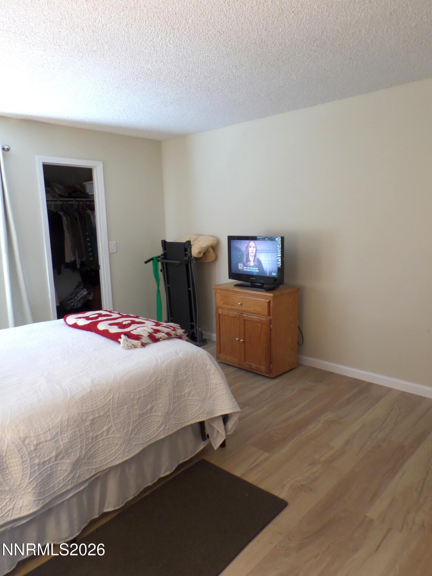 3890 East Leonesio Drive, Unit D1 Reno, NV 89512 - Photo 17 of 32 a bed sitting in a bedroom and a table