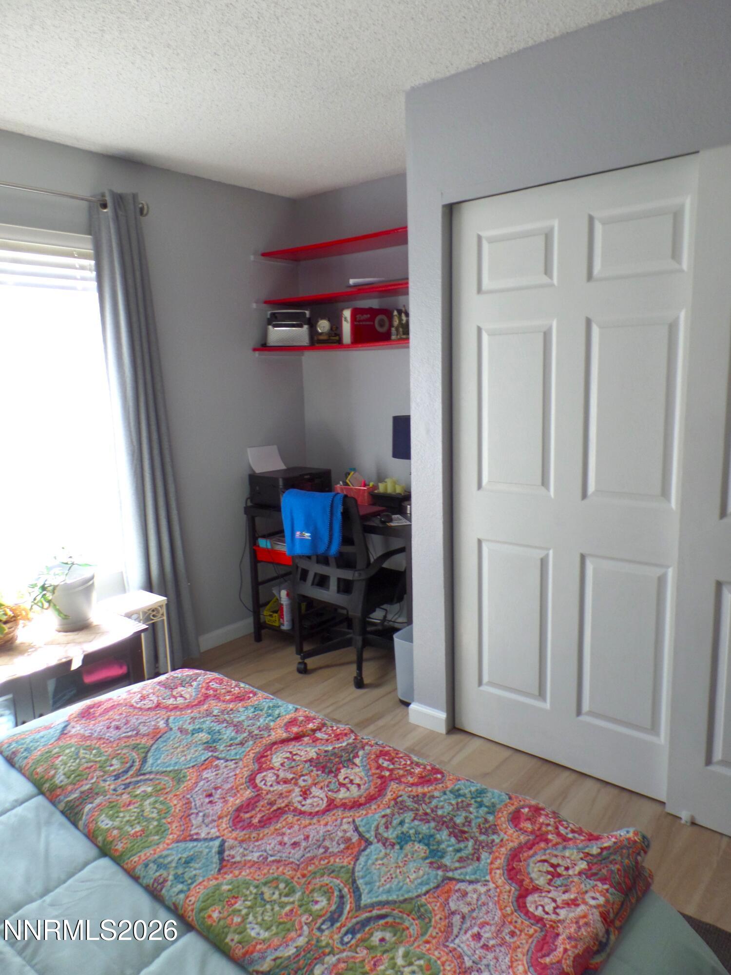3890 East Leonesio Drive, Unit D1 Reno, NV 89512 - Photo 23 of 32 a bedroom with a bed and a dresser in it