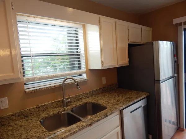 a kitchen with a sink cabinets and refrigerator