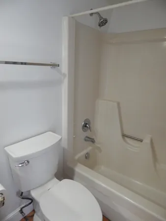 a white toilet sitting next to a bath tub