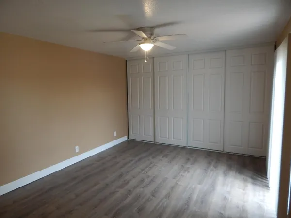 a view of an empty room with wooden floor