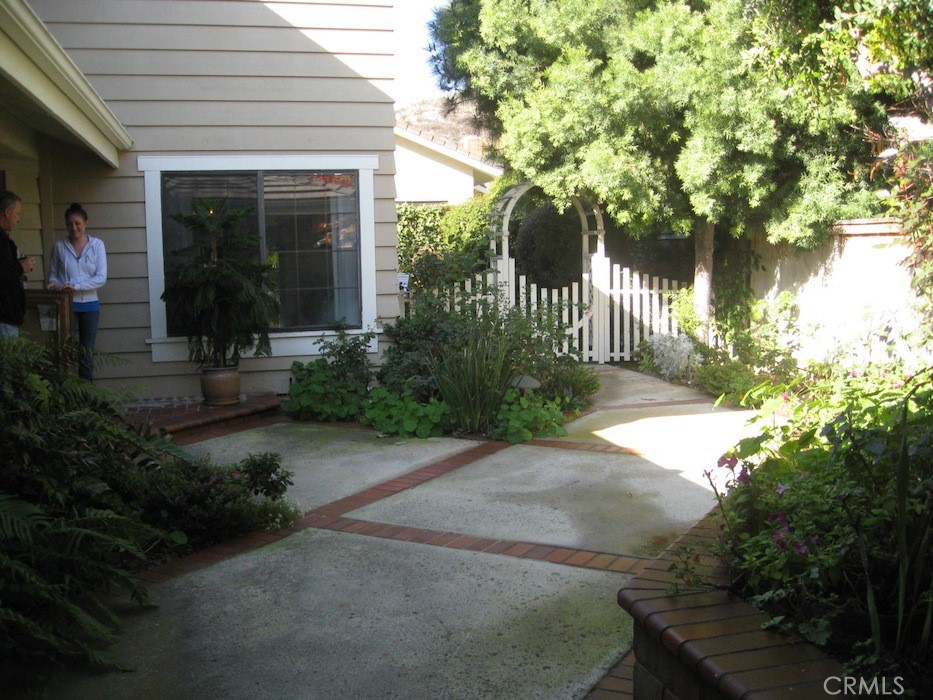 25 Morning Breeze, Unit 46 Irvine, CA 92603 - Photo 23 of 26 a front view of a house with a yard and potted plants