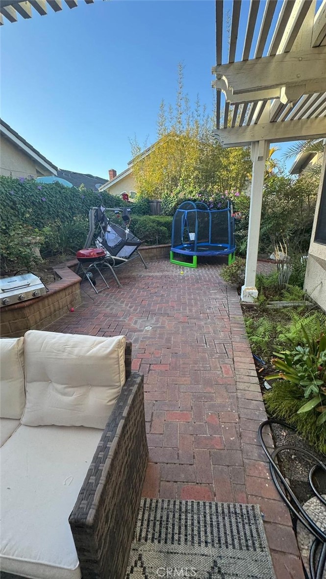 25 Morning Breeze, Unit 46 Irvine, CA 92603 - Photo 6 of 26 a view of a patio with table and chairs under an umbrella