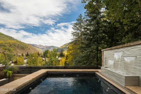 a backyard of a house with lots of green space and fountain view