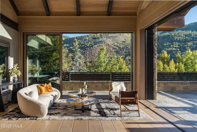 a living room with patio furniture and a potted plant
