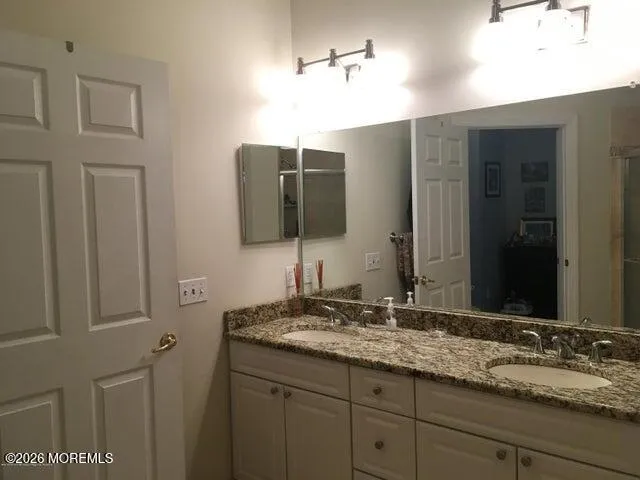 a bathroom with a granite countertop sink and a mirror