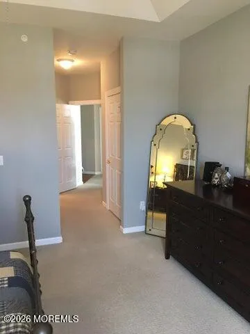 a view of a entryway door with a lamp on a table and a mirror