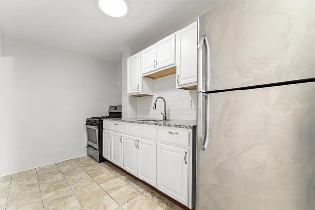 a kitchen with a sink cabinets and a refrigerator