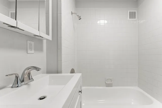 a bathroom with a tub sink and vanity