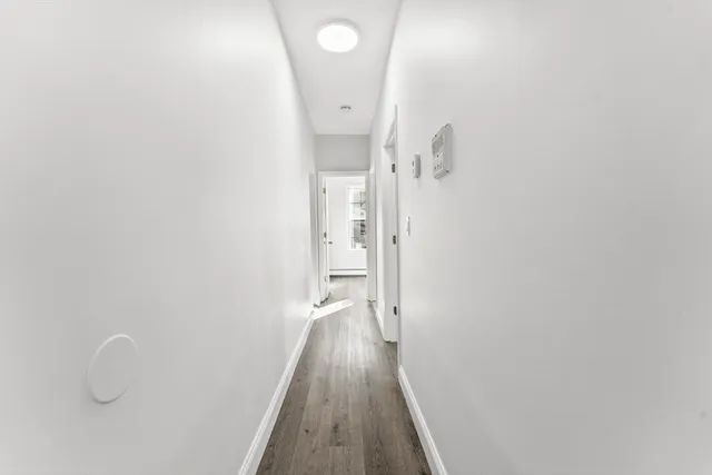 a view of a hallway with wooden floor