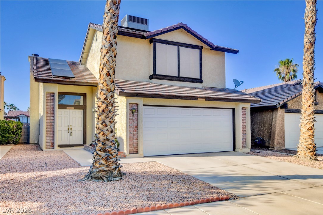 6440 Hartwood Road Las Vegas, NV 89108 - Photo 2 of 59 A cream-colored home with a terracotta tile roof and an attached two-car garage awaits.