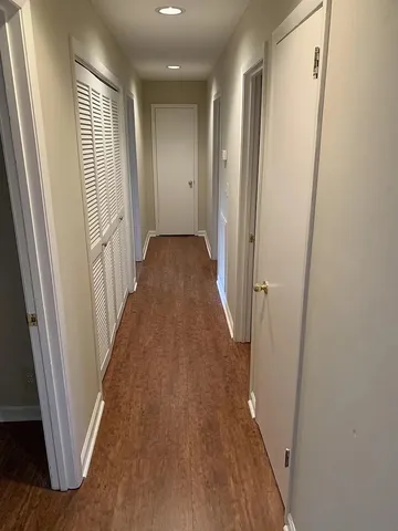 a view of a hallway with wooden floor and staircase
